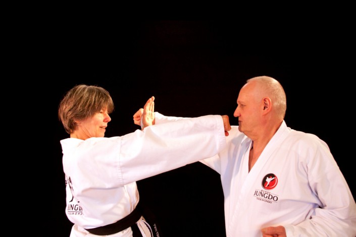 Taekwondo senioren üben Angriff und Abwehrsezenario gegen Faustangriff
